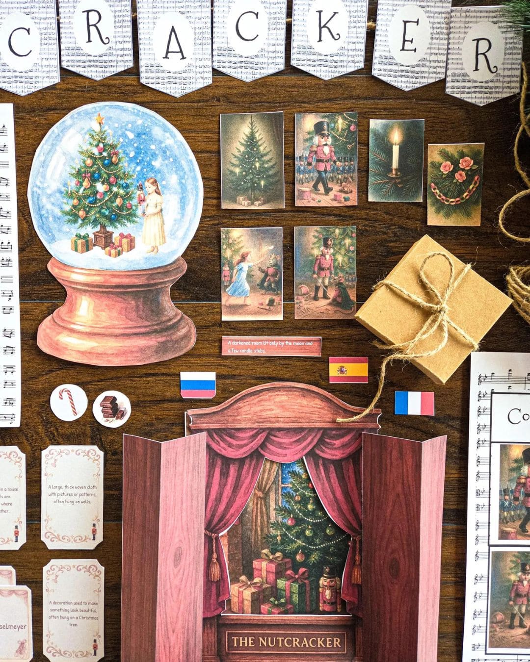 Decorative scene with a snow globe, gift box, and theater set on a wooden background with 'The Nutcracker' book study theme.