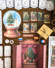 Decorative scene with a snow globe, gift box, and theater set on a wooden background with 'The Nutcracker' book study theme.