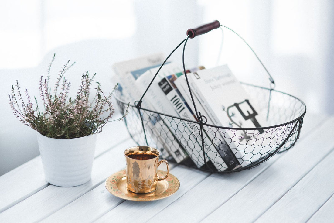 Homeschool morning basket of books with a warm cup of tea on a wooden table