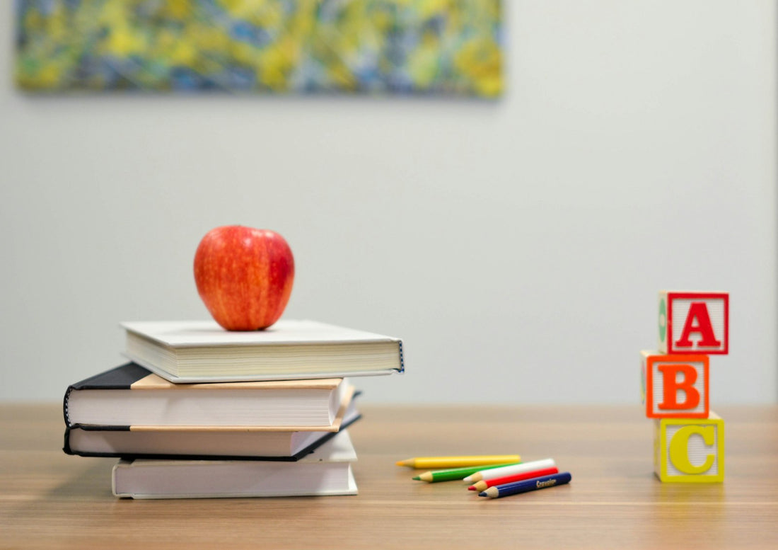 A red apple resting on a stack of books, a classic back-to-school still life