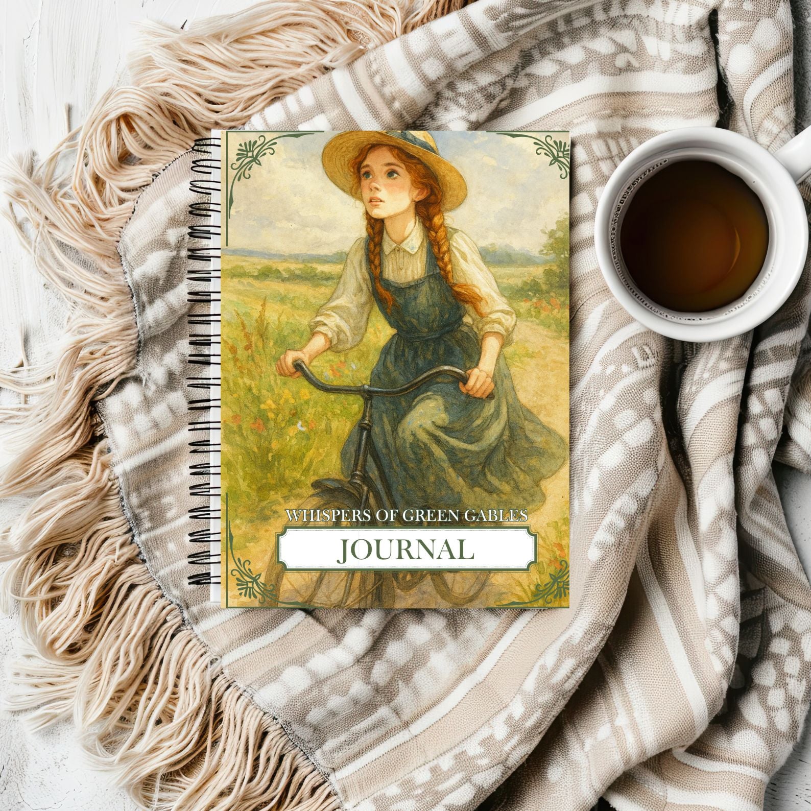 Journal cover titled “Whispers of Green Gables” with illustration of Anne riding a bicycle, styled with cozy throw blanket and tea