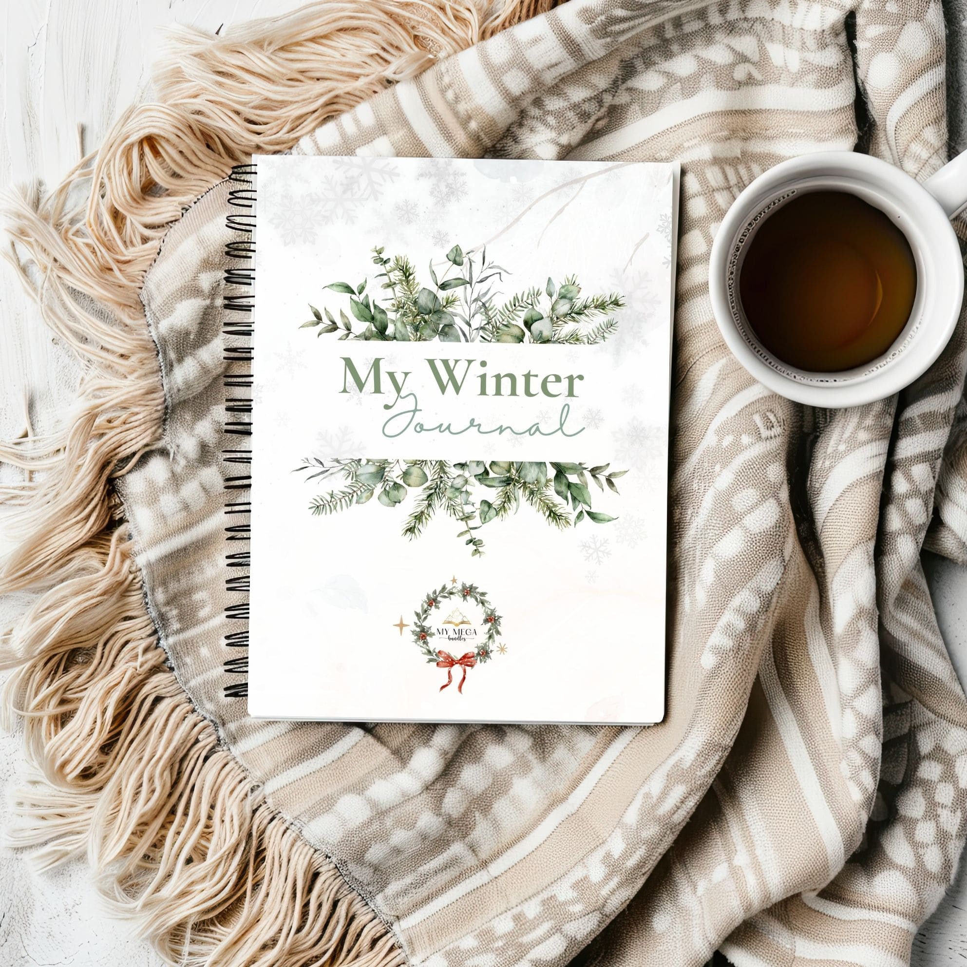 Winter journal with decorative cover on a textured blanket with a cup of coffee.