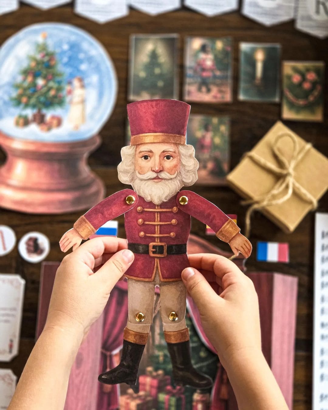 Person holding a paper toy of a festive character from Nutcracker with a Christmas-themed background