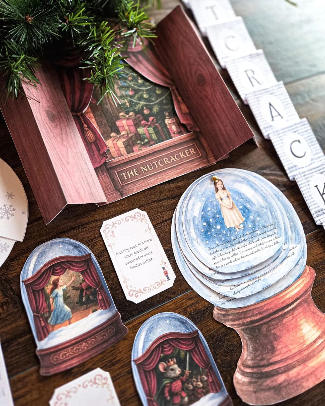 Christmas-themed cards and decorations with 'The Nutcracker' design on a wooden surface.