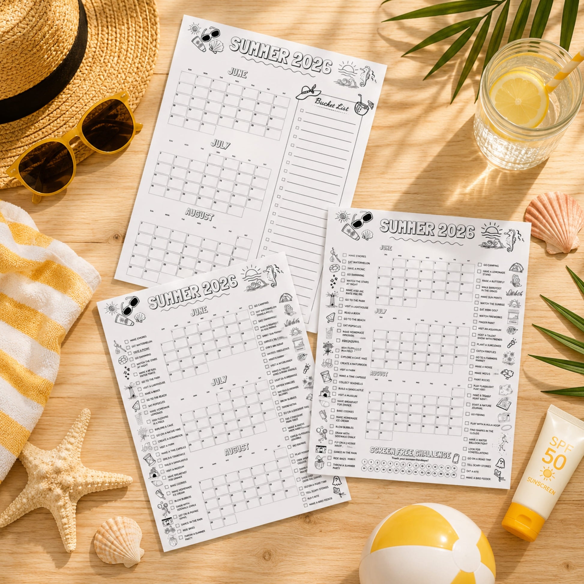 Three 'Summer 2023' planners on a wooden surface with beach accessories.